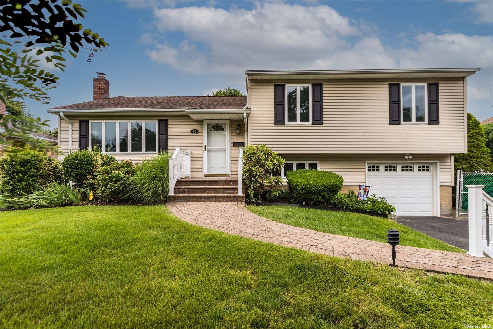 66 Colony Lane Syosset, NY 11791 - Photo 1 of 1 a front view of a house with a yard and garage