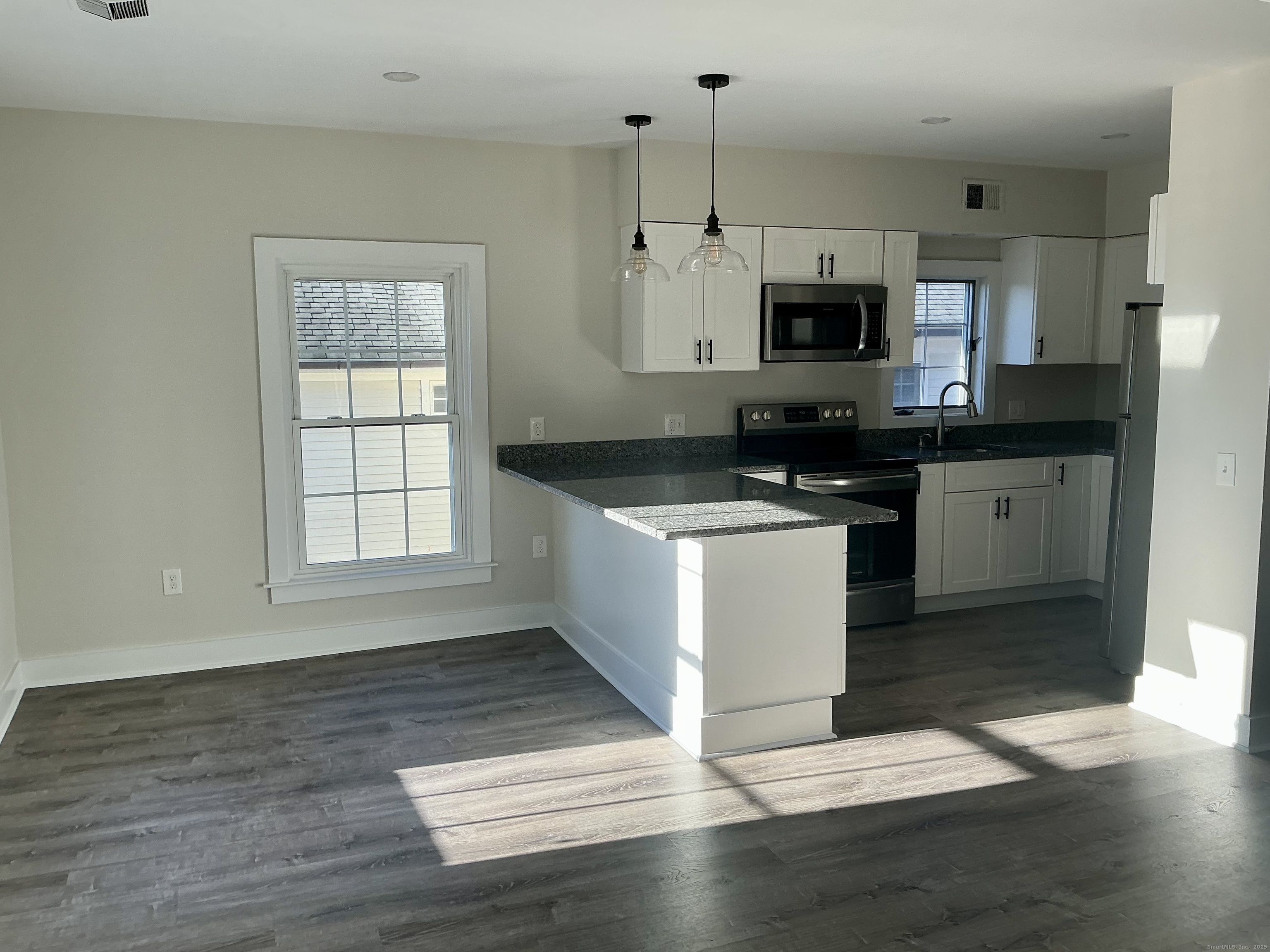 17 Willow Street, Unit 2 Mystic, CT 06355 - Photo 4 of 20 a kitchen with stainless steel appliances granite countertop a stove a sink and a microwave