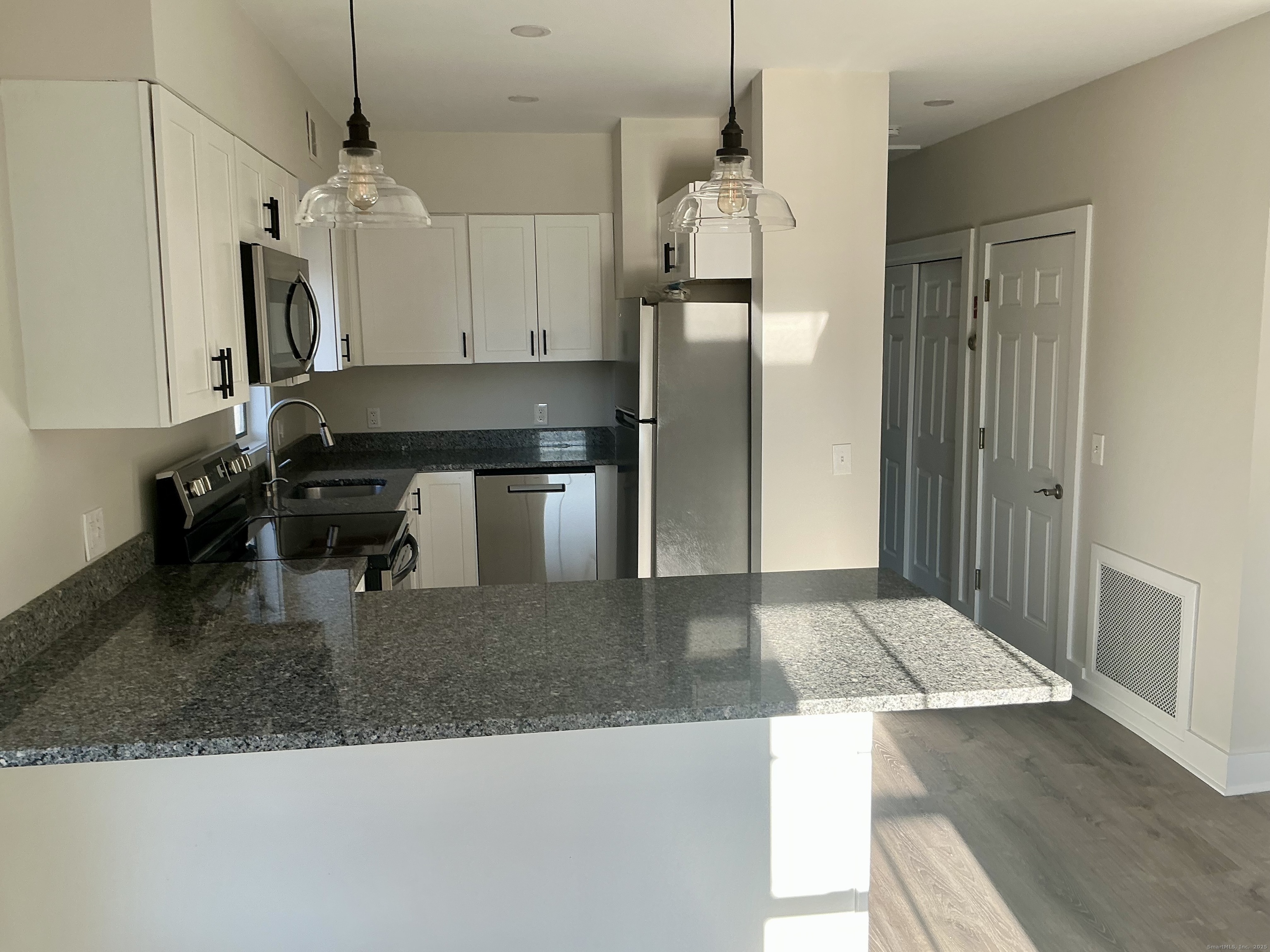 17 Willow Street, Unit 2 Mystic, CT 06355 - Photo 5 of 20 a kitchen with kitchen island a counter top space a sink a refrigerator and a counter top space