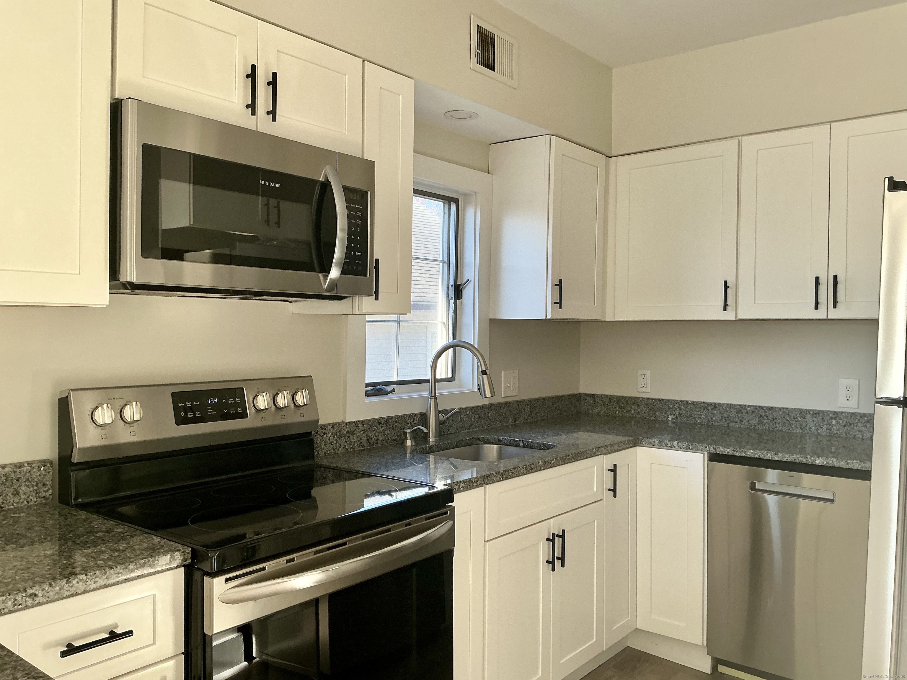 17 Willow Street, Unit 2 Mystic, CT 06355 - Photo 6 of 20 a kitchen with a stove and microwave