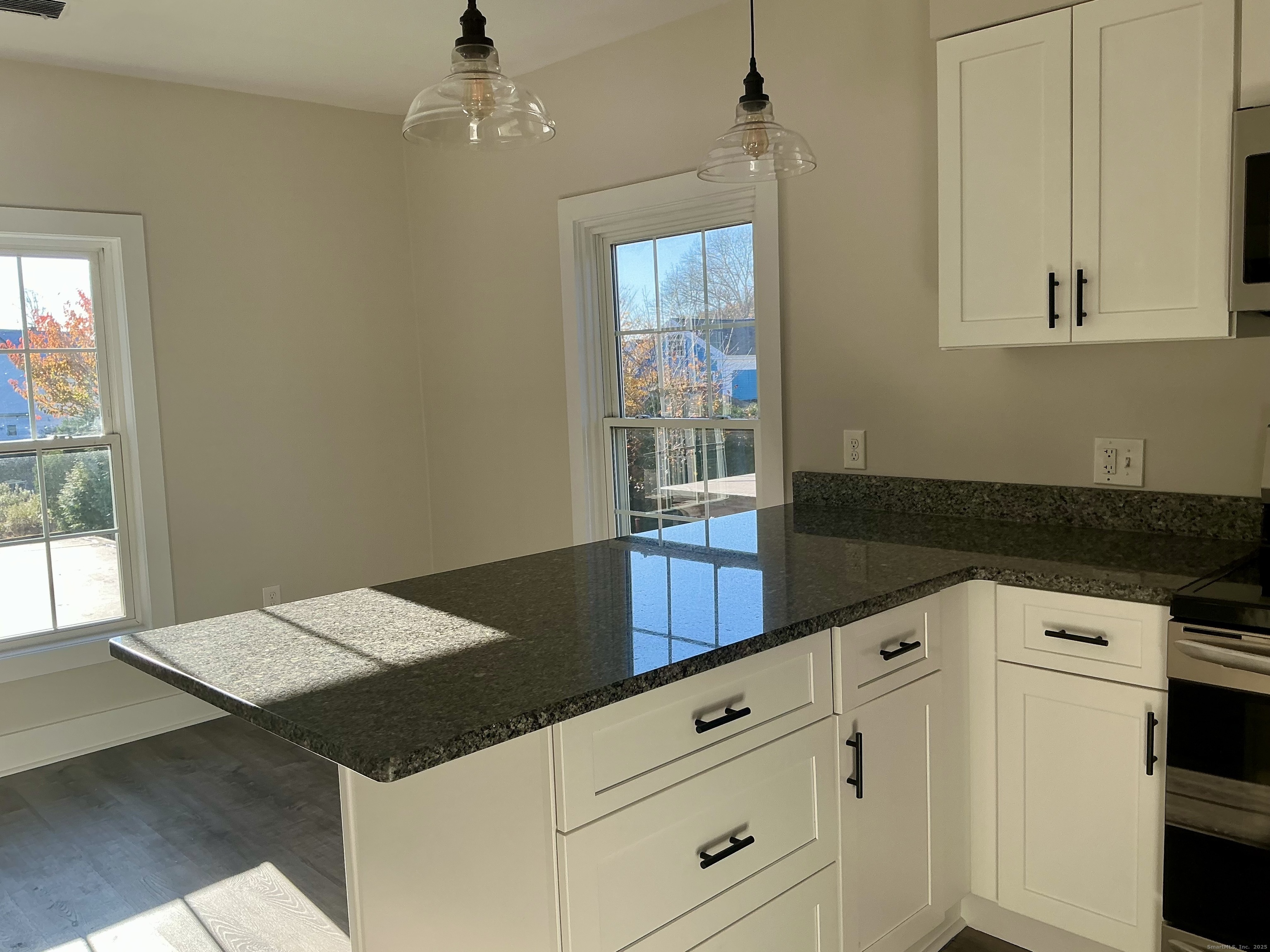 17 Willow Street, Unit 2 Mystic, CT 06355 - Photo 7 of 20 a kitchen with a stove and white cabinets