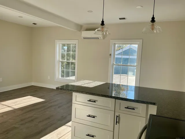 a kitchen with granite countertop white cabinets and white appliances