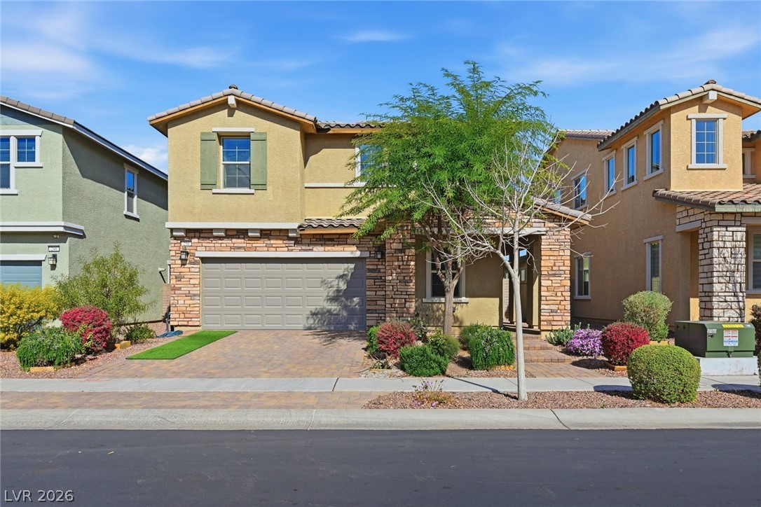 250 Dedication Avenue Henderson, NV 89011 - Photo 1 of 67 Mediterranean / spanish home with stone siding, an attached garage, stucco siding, decorative driveway, and a tiled roof