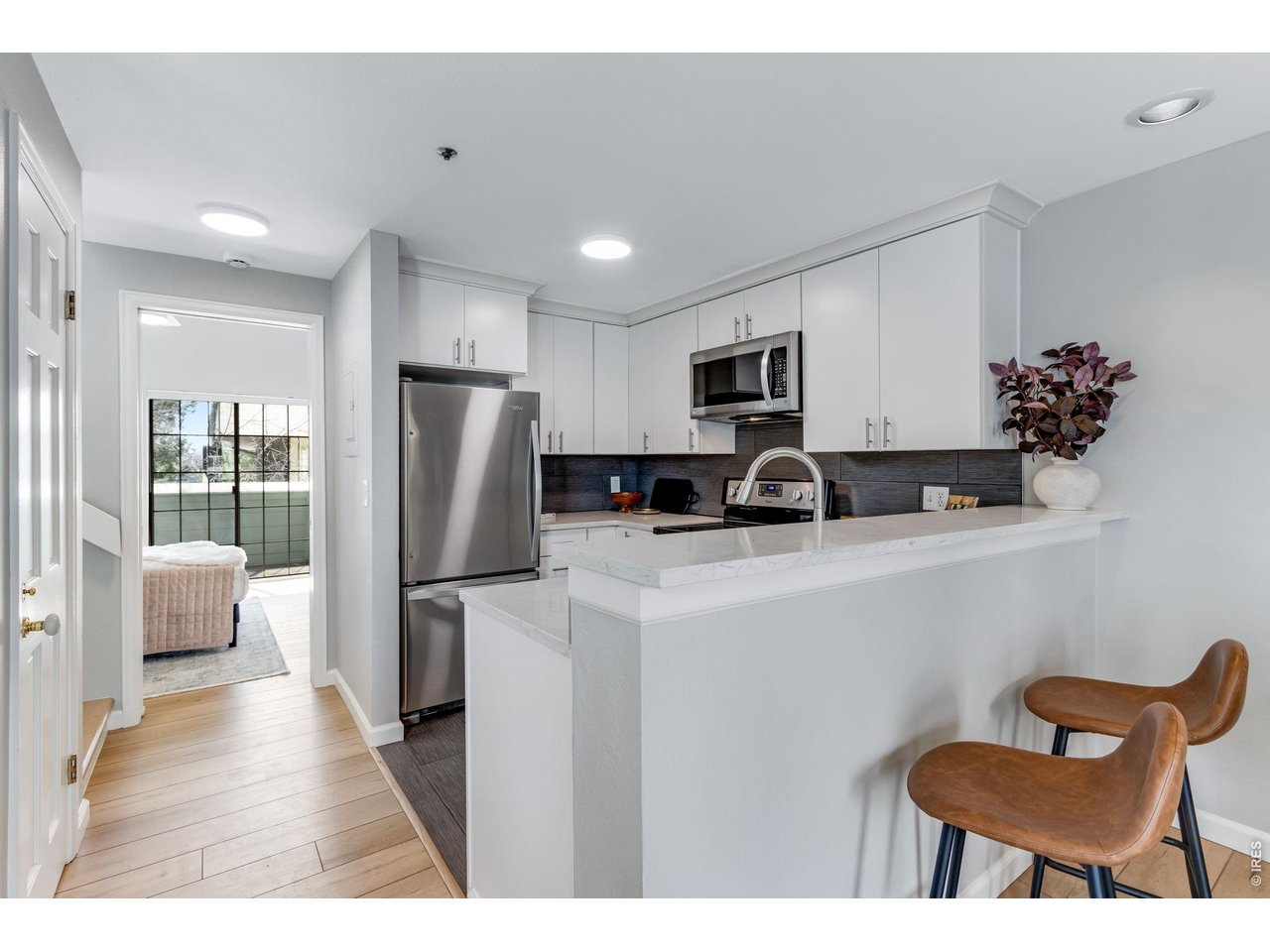 3473 28th Street, Unit 12 Boulder, CO 80301 - Photo 23 of 39 a kitchen with stainless steel appliances granite countertop a refrigerator a stove a sink a dining table and chairs with wooden floor