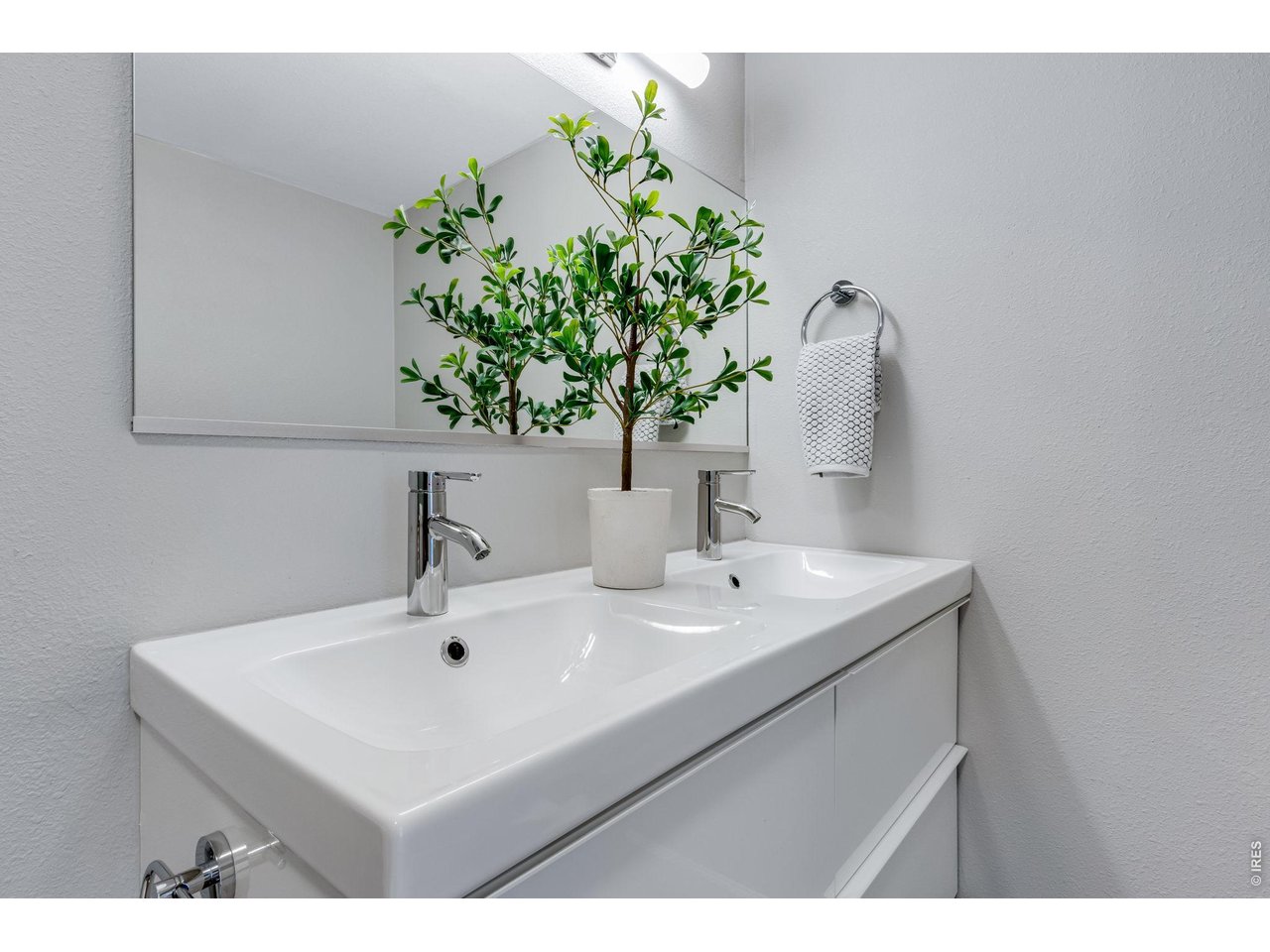 3473 28th Street, Unit 12 Boulder, CO 80301 - Photo 24 of 39 a bathroom with a sink a mirror and a potted plant