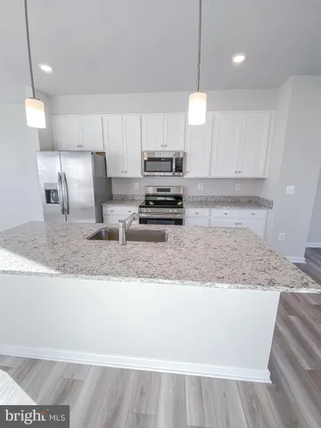 a kitchen with kitchen island a counter top space a sink and appliances