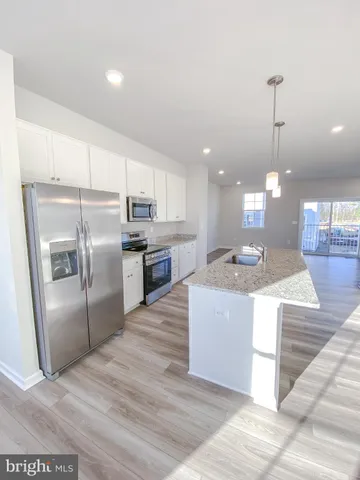 a kitchen with kitchen island a counter top space a sink and stainless steel appliances