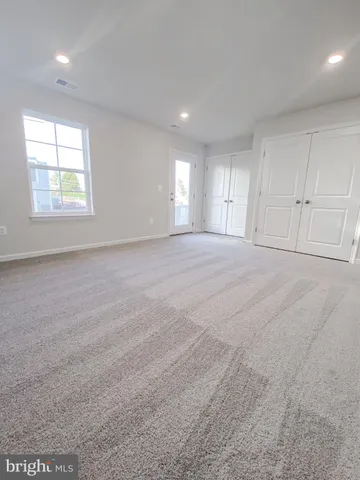 an empty room with windows and closet