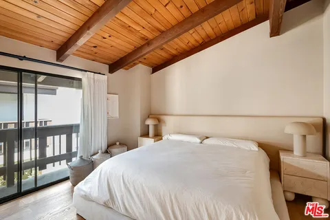 a bedroom with a large bed and a balcony