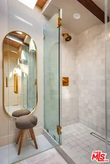 a bathroom with a glass shower door and a mirror