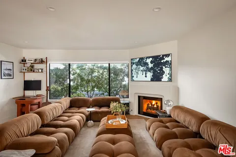a living room with furniture a fireplace and a large window