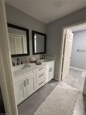 a spacious bathroom with a double vanity sink and a mirror