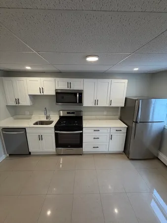 a kitchen with stainless steel appliances a stove a sink and a refrigerator