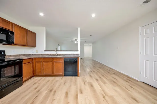 a kitchen with stainless steel appliances granite countertop a sink and a stove top oven