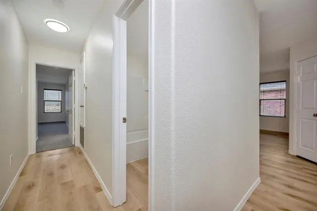 a view of a hallway with wooden floor and staircase
