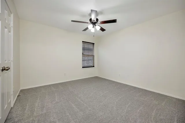 an empty room with closet and fan