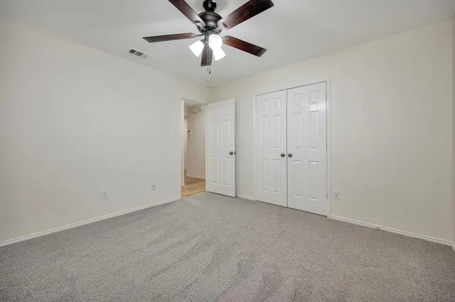 an empty room with chandelier fan