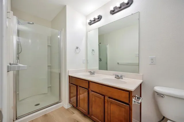 a bathroom with a sink a toilet and shower