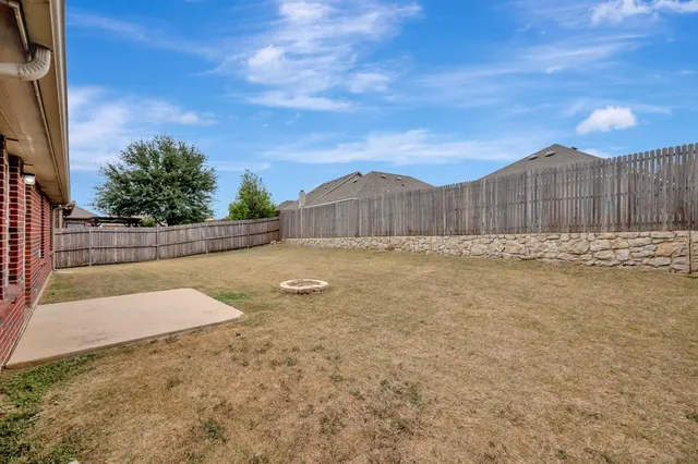 a view of backyard with wooden fence