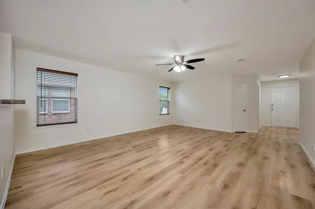 a view of an empty room with a chandelier fan