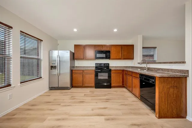 a kitchen with stainless steel appliances granite countertop a refrigerator and a stove top oven