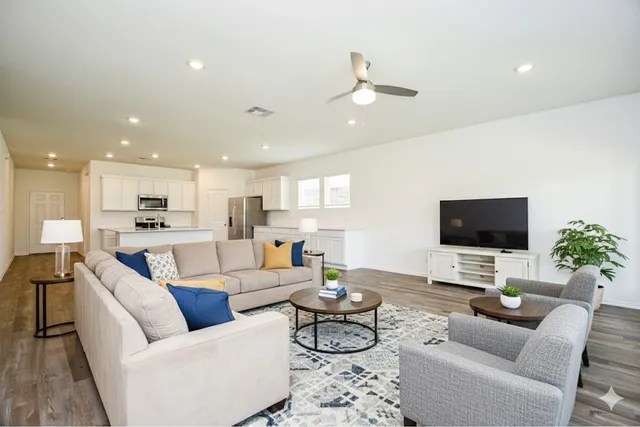 a living room with furniture kitchen view and a flat screen tv