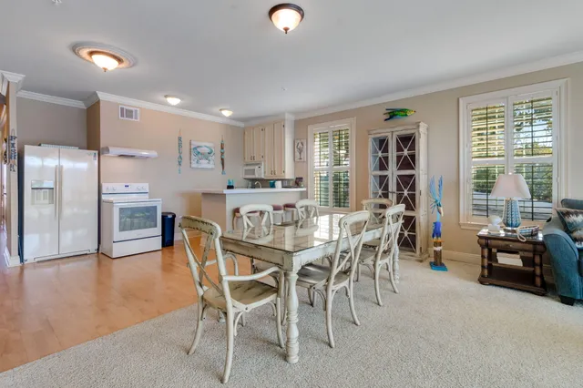 a dining room with furniture potted plants and wooden floor