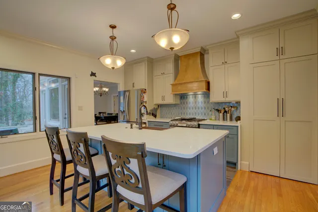 a kitchen with a dining table chairs and white cabinets