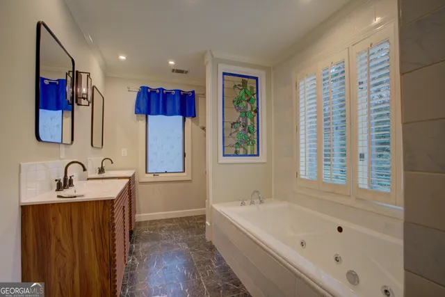 a bathroom with a tub a sink and a window