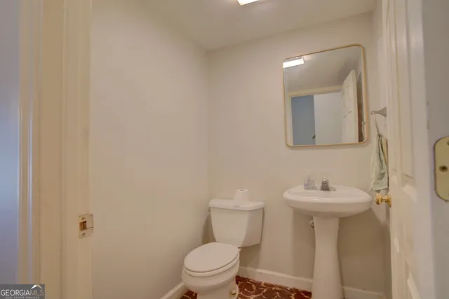 a bathroom with a sink toilet and a mirror