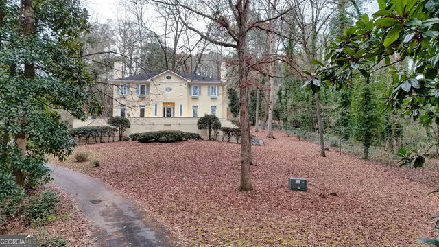 a front view of a house with a tree
