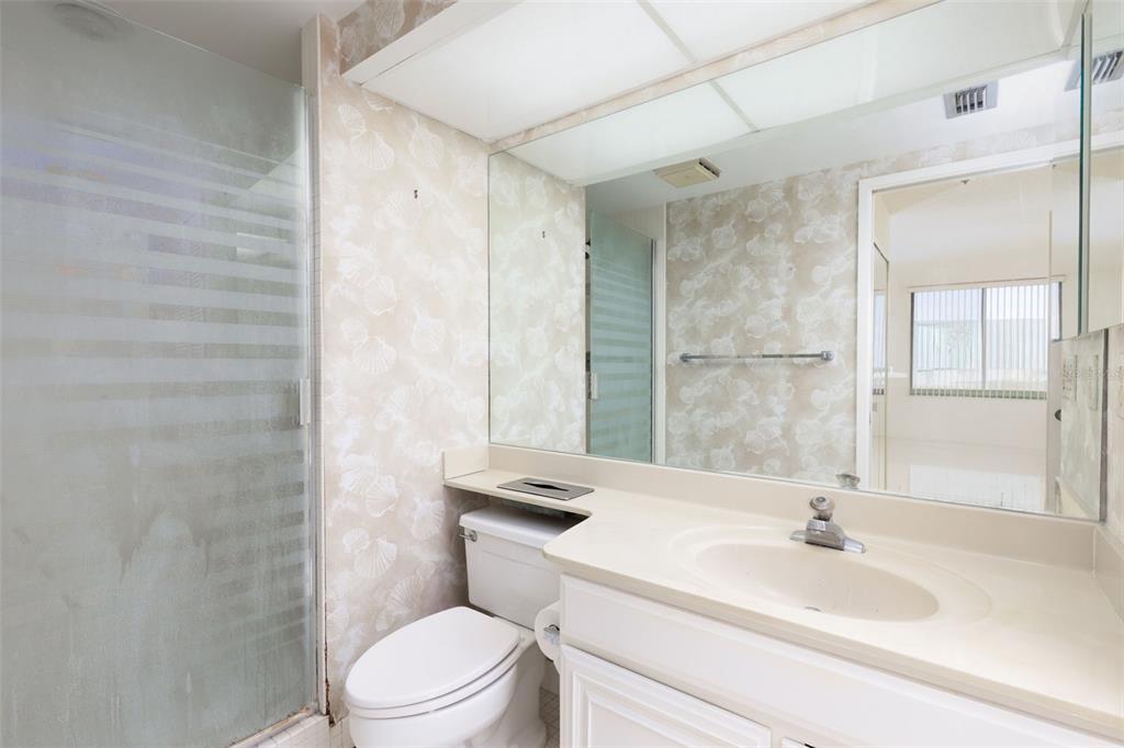 9525 Blind Pass Road, Unit 508 St. Pete Beach, FL 33706 - Photo 15 of 24 a bathroom with a sink a toilet and shower