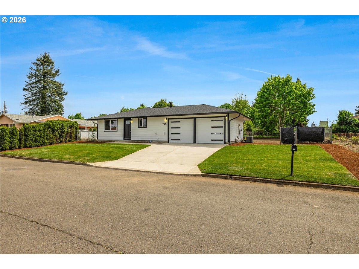 795 Northwest 6th Avenue Canby, OR 97013 - Photo 2 of 40 a front view of a house with a yard and garage