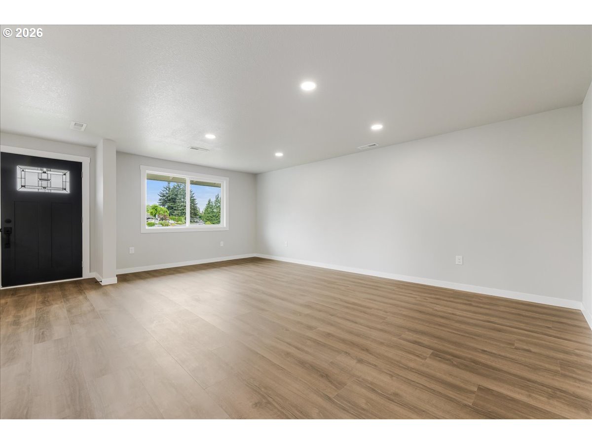 795 Northwest 6th Avenue Canby, OR 97013 - Photo 7 of 40 an empty room with wooden floor and windows