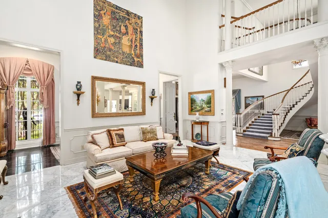 a living room with furniture a rug and a painting on the wall