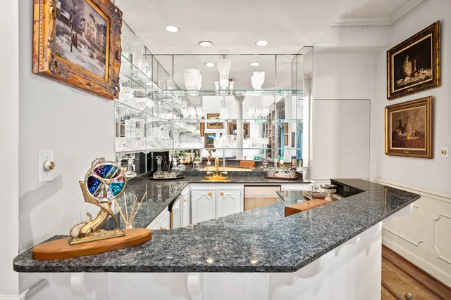 a view of a kitchen with granite countertop lots of clutter and stainless steel appliances