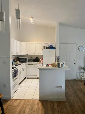 a kitchen with cabinets a sink and white appliances