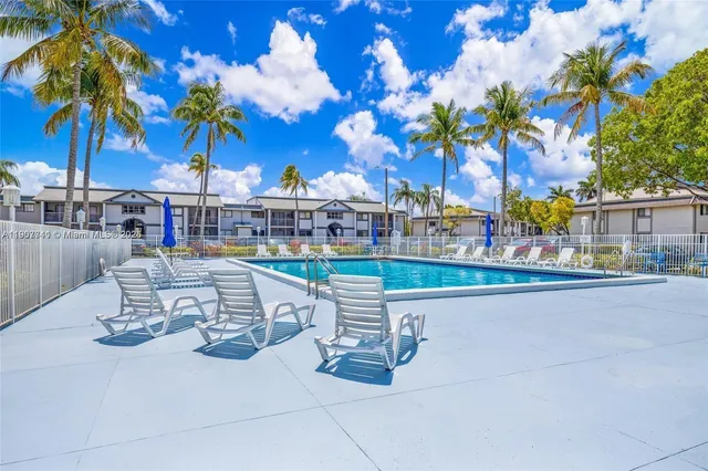 a roof deck view with lawn chairs under an umbrella
