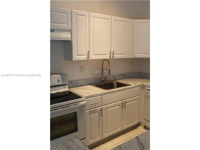 a kitchen with a sink cabinets and appliances