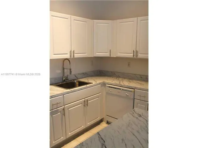 a kitchen with a sink cabinets and appliances
