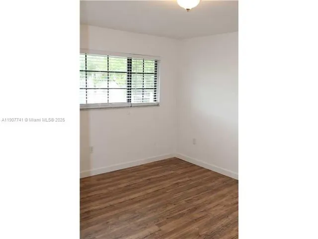 a view of a room that has wooden floor and windows in it