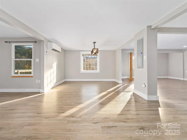 a view of a big room with wooden floor and windows