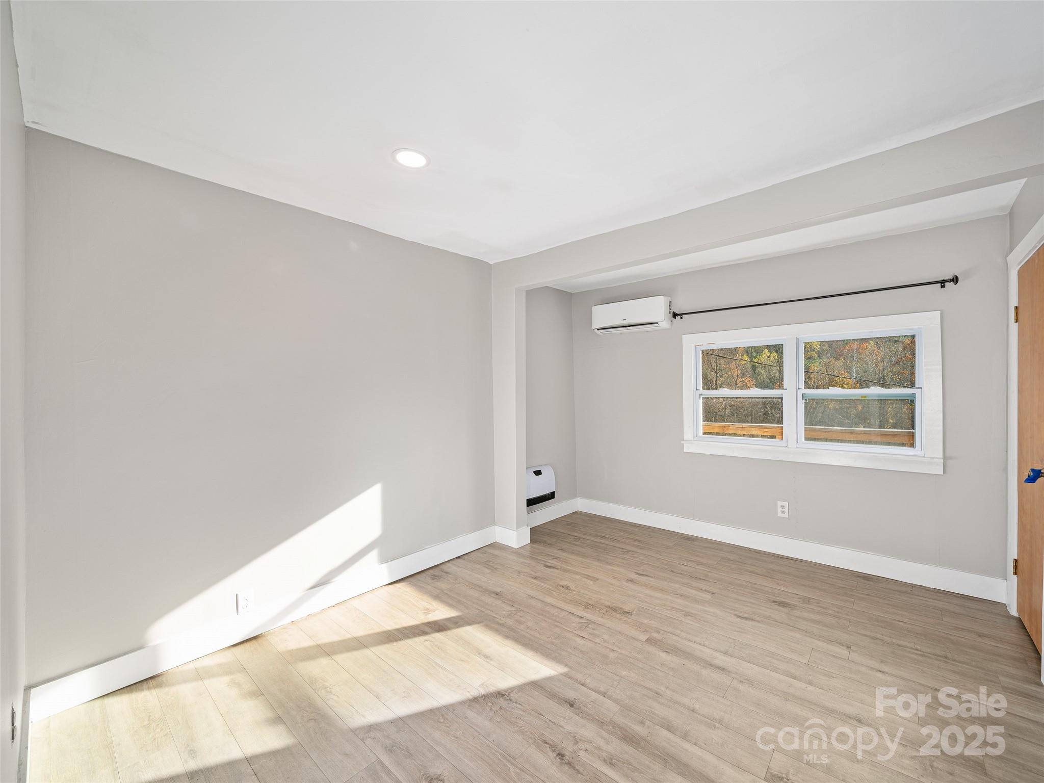 3477 Cane Creek Road Bakersville, NC 28705 - Photo 23 of 30 a view of an empty room with wooden floor and a window