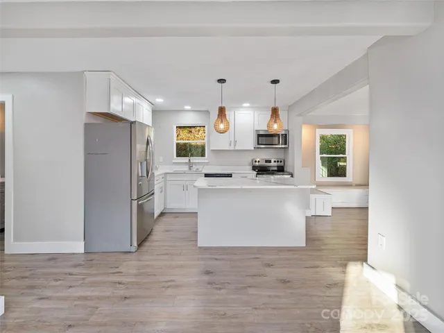 a kitchen with stainless steel appliances a refrigerator sink and cabinets