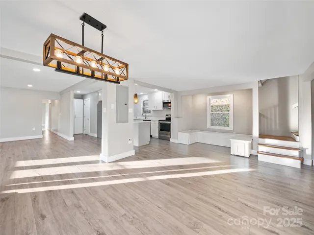 a view of a living room and kitchen with furniture wooden floor and window
