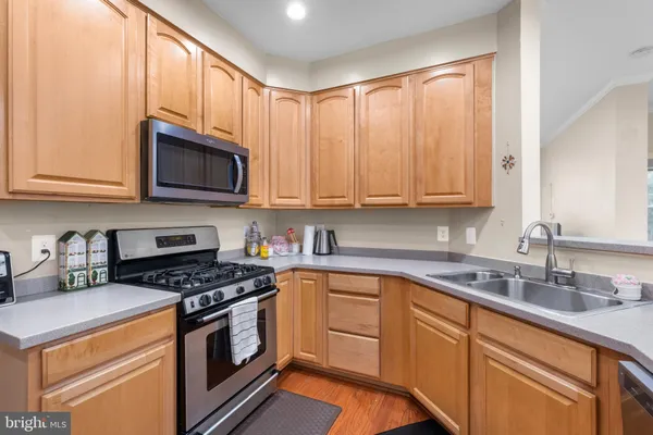 a kitchen with granite countertop white cabinets sink and stainless steel appliances
