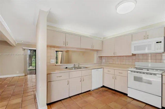 a kitchen with white cabinets stainless steel appliances and sink