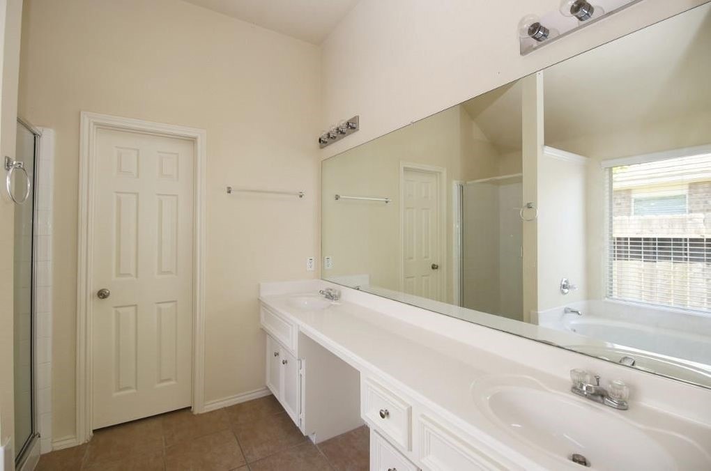 17223 Valhallah Way Houston, TX 77095 - Photo 11 of 14 a bathroom with a tub sink and mirror