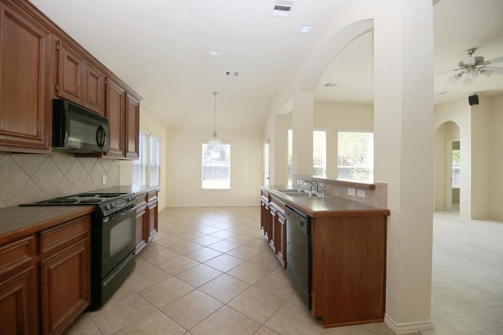 17223 Valhallah Way Houston, TX 77095 - Photo 6 of 14 a kitchen with stainless steel appliances granite countertop a stove and a sink