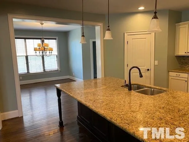 a kitchen with kitchen island a sink appliances and a window